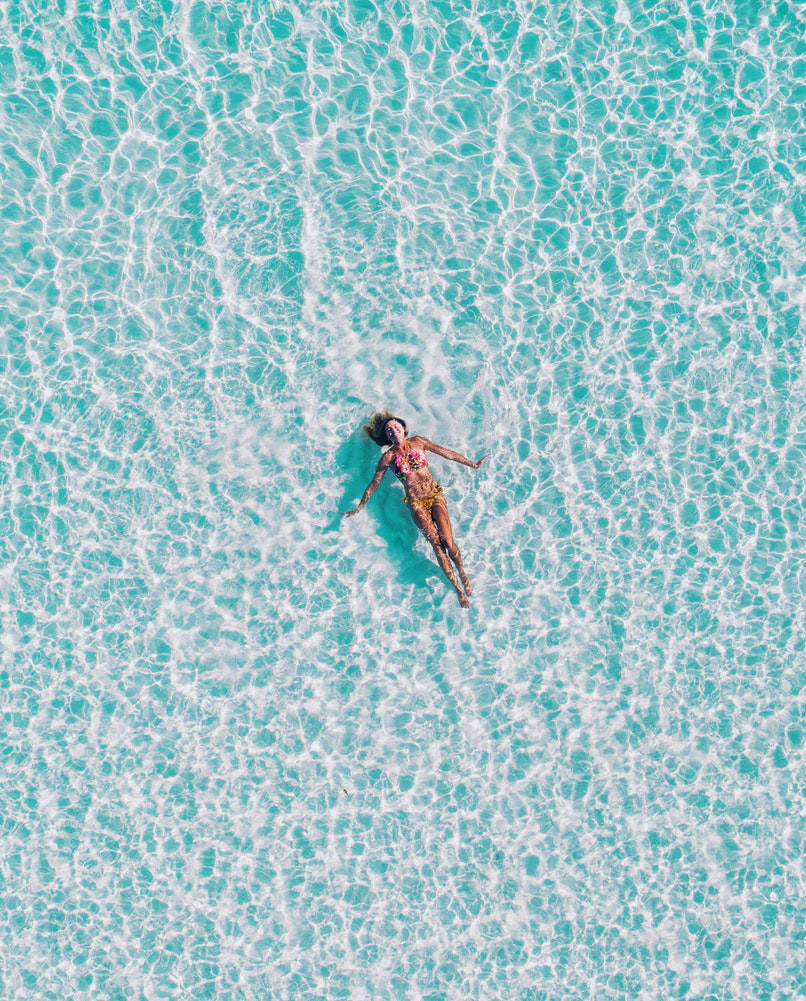 Une femme sereine nage dans l'eau car elle a mis moins de temps de transport